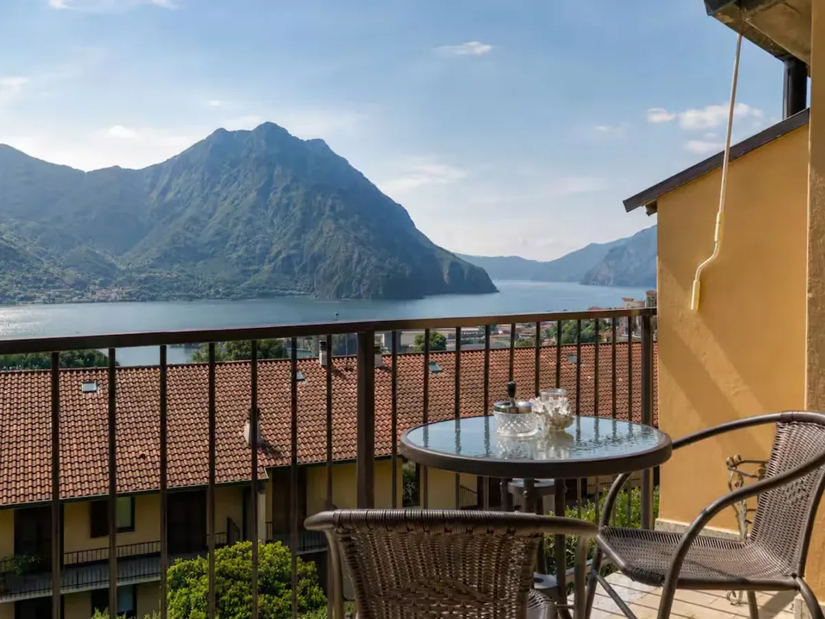 The balcony at Luer Prince Residence in Lovere, with a small table and a view of Lake Iseo and the mountains