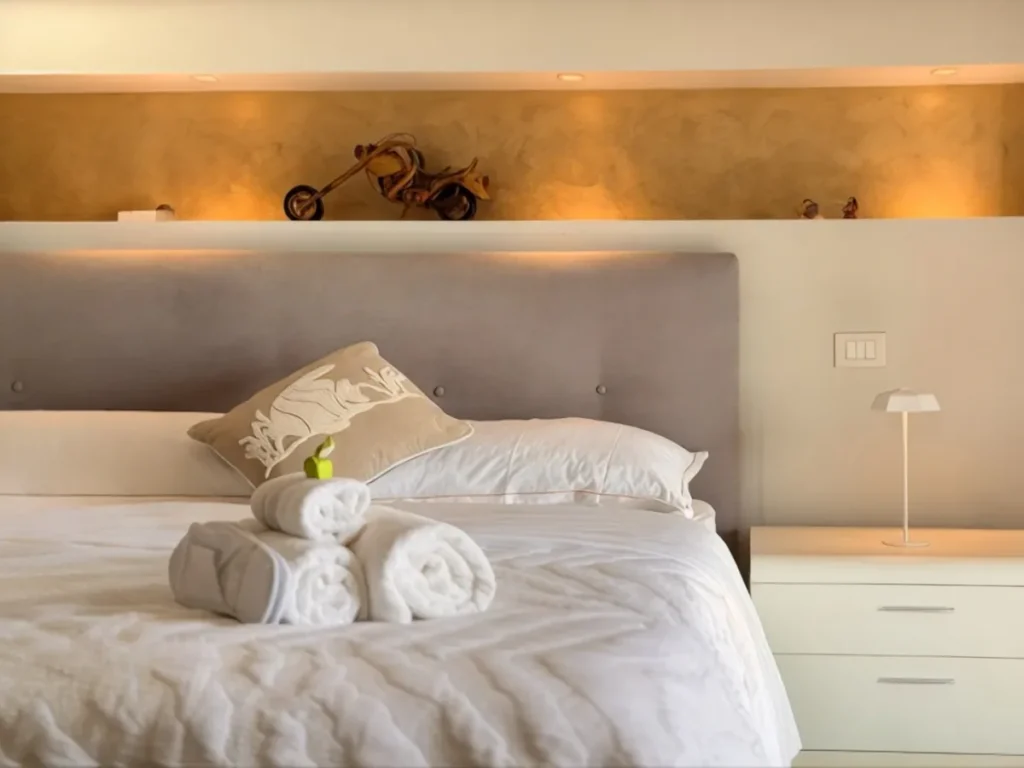 Camera da letto di Luer Prince Residence a Lovere, letto matrimoniale con asciugamani e luce calda